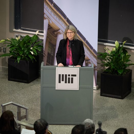 Sally Kornbluth addresses an audience, speaking behind a lectern.