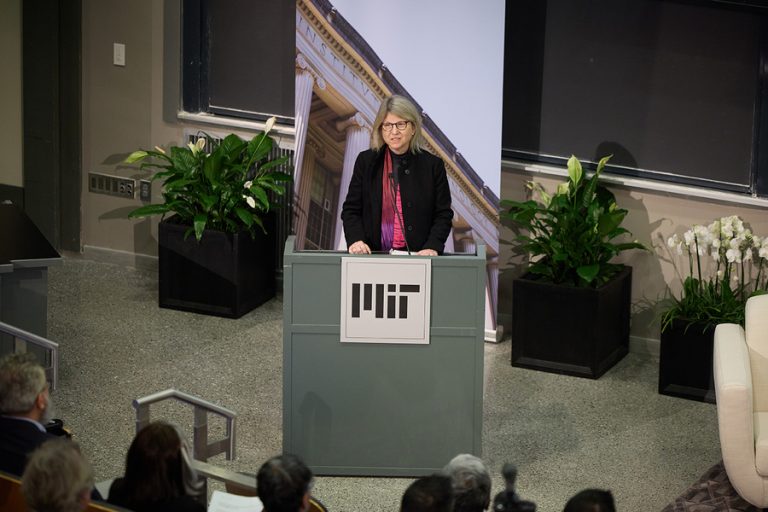 Sally Kornbluth addresses an audience, speaking behind a lectern.