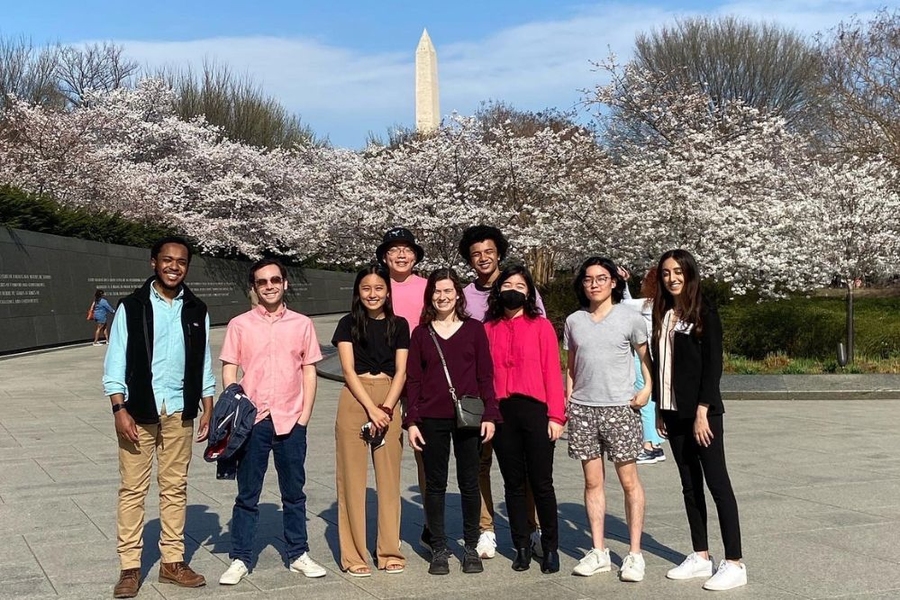 9 Students pose against a bank of cherry blossoms in front of the Washington Monument.