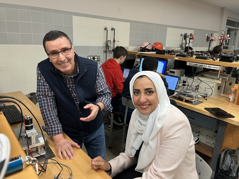 Kamal Youcef-Toumi and Amira Alazmi pose in a bench lab filled with technical equipment