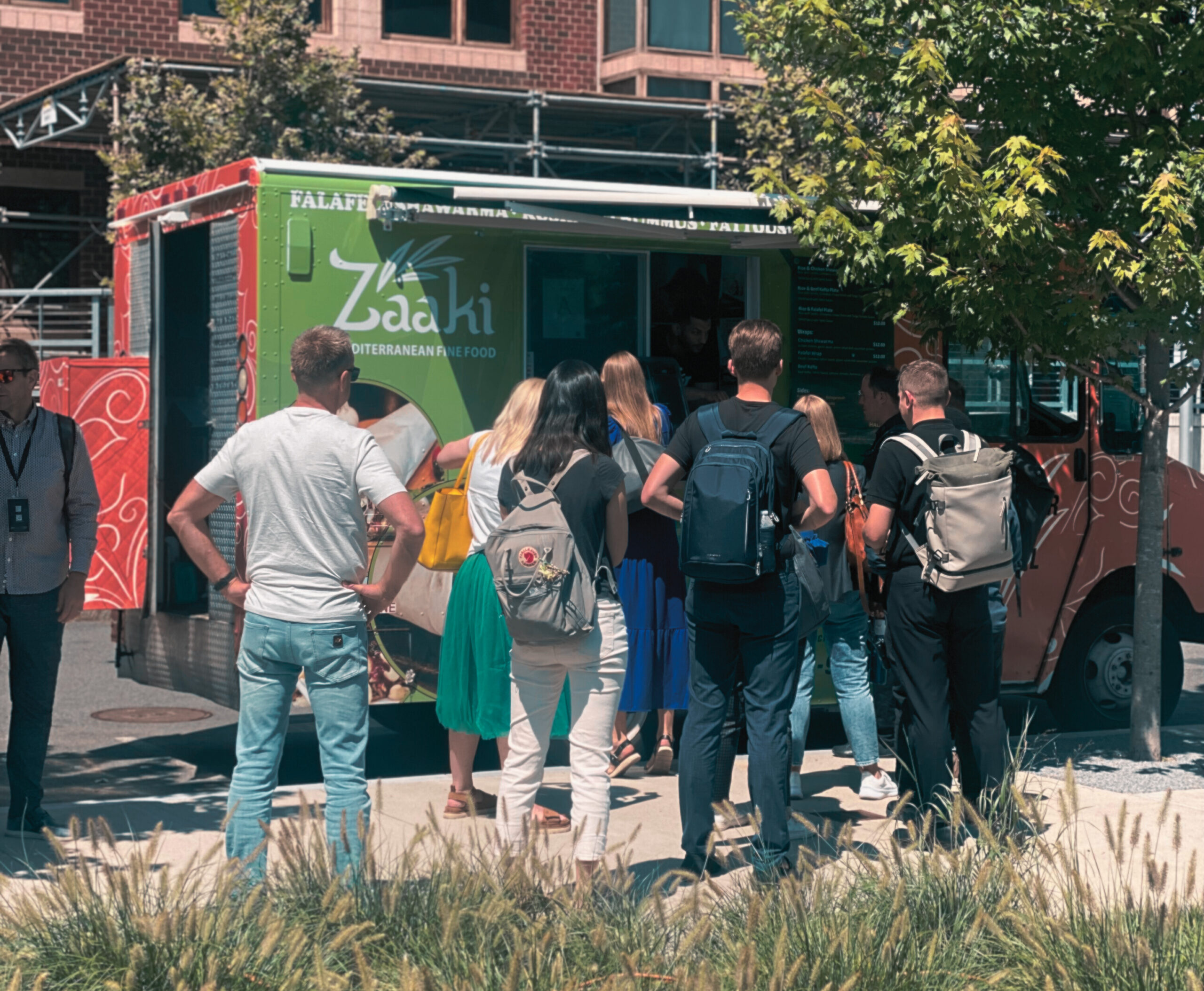 Eight people gather outside the Zaaki food truck.