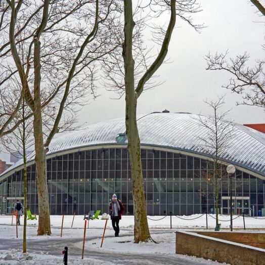 A photo of Kresge Auditorium covered in snow with students walking in winter jackets.