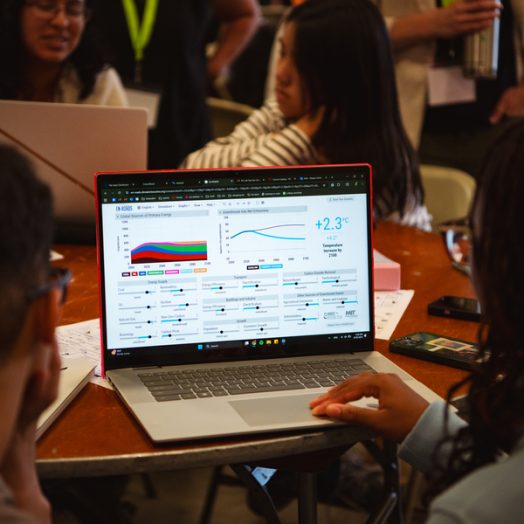 Students look at the En-ROADS simulator on a laptop screen