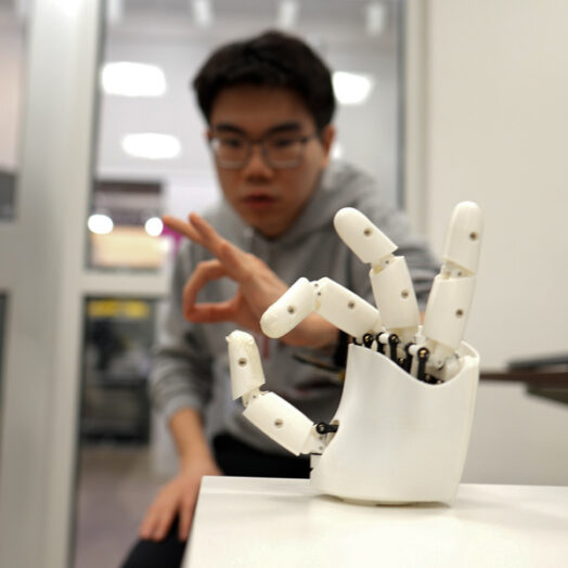 A researcher working with a robotic hand